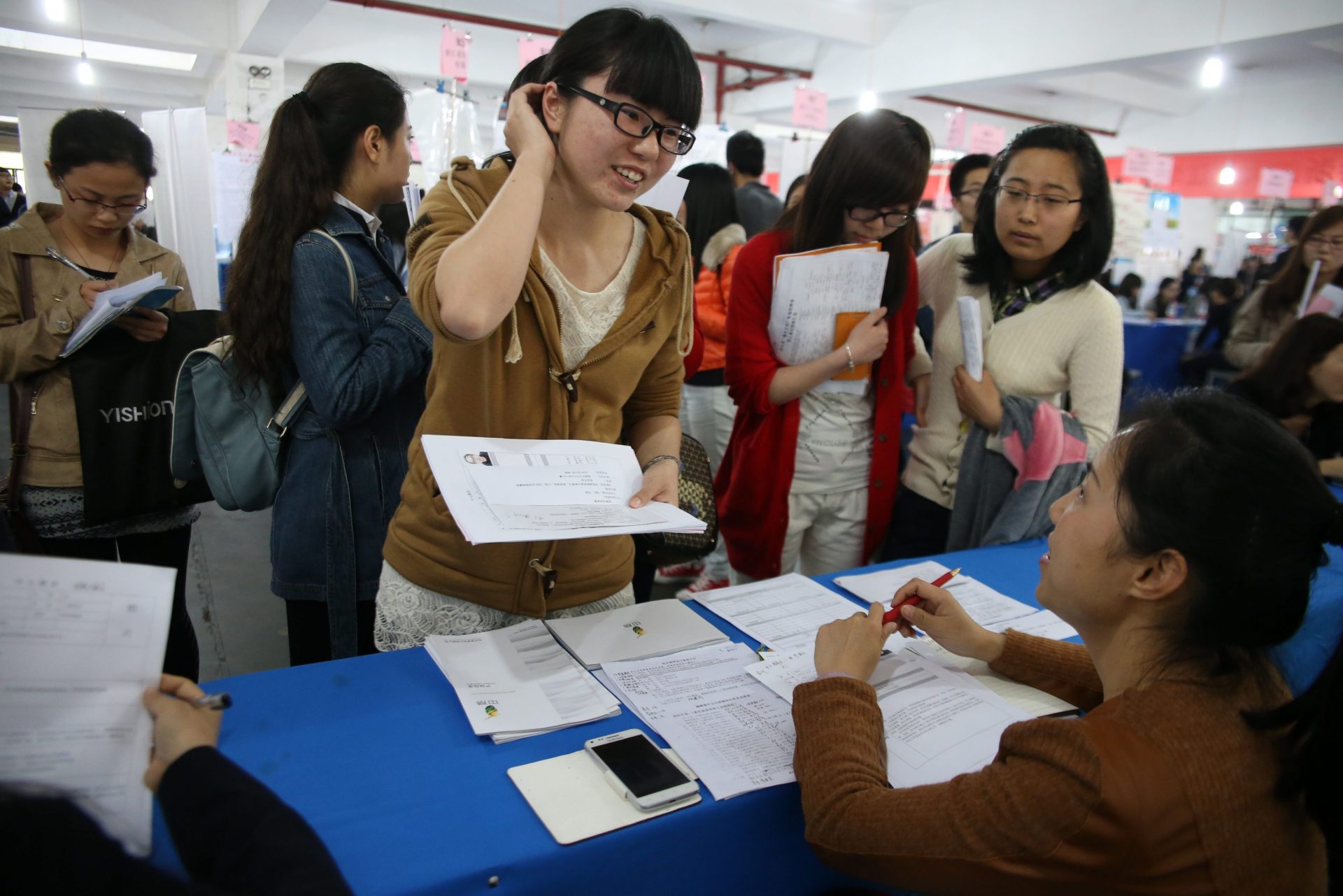 Foto LUSA: Uma estudante chinesa recém formada à procura de colocação no mercado de trabalho. Hangzhou, província de Zhejiang, China, 28 de março de 2014. EPA / WU HONG