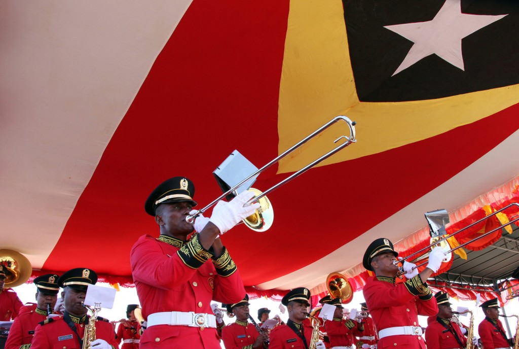 epa05045261 An East Timorese military brass band marches under a giant national flag during a parade to mark the restoration of their independence, in Dili, East Timor, also known as Timor Leste, 28 November 2015. East Timor was colonized by Portugal in the 16th century, until Portugal's decolonization of the country. In late 1975 East Timor declared its independence but was occupied by Indonesia that declared it as the country's 27th province the following year. In 1999, following the United Nations-sponsored act of self-determination, Indonesia relinquished control of the territory and East Timor became the first new sovereign state of the twenty-first century on 20 May 2002. EPA/ANTONIO DASIPARU